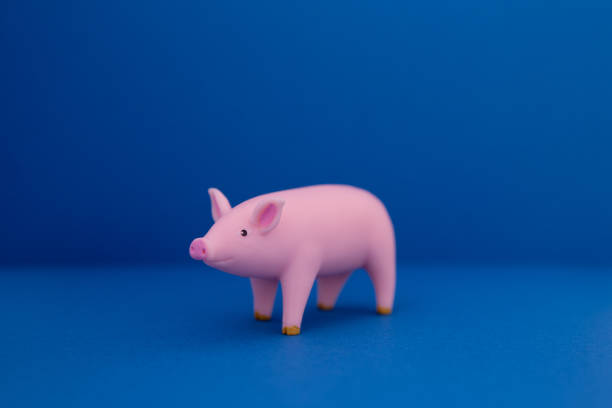 Pink pig made of plastic on blue background