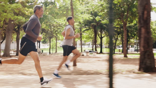 Men, running or outdoor park for athletes in fitness, workout or run training. Nature trail, wellness or exercising male friends or mature personal trainer runner in sports cardio, health or exercise