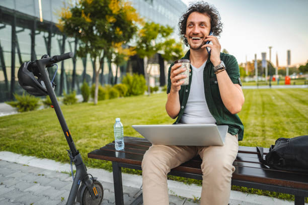 istock Men talking on the phone and drinking coffee while taking a break from working in public park 1511476796