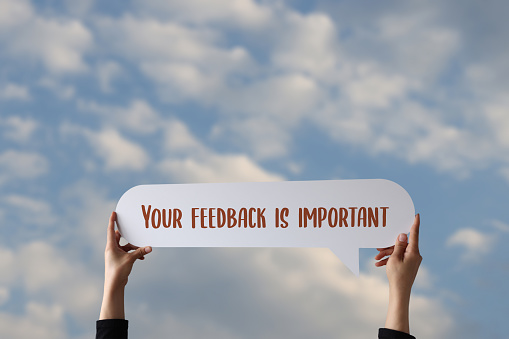 Woman holding speech bubble with your feedback is important text