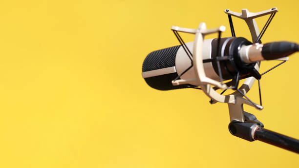 Close up of a modern microphone against yellow background
