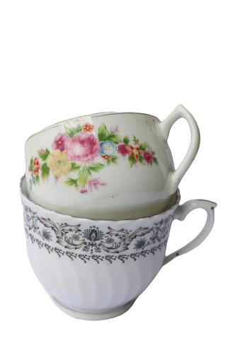 Porcelain cups, beautiful porcelain cups arranged on rustic wood, dark background, selective focus.