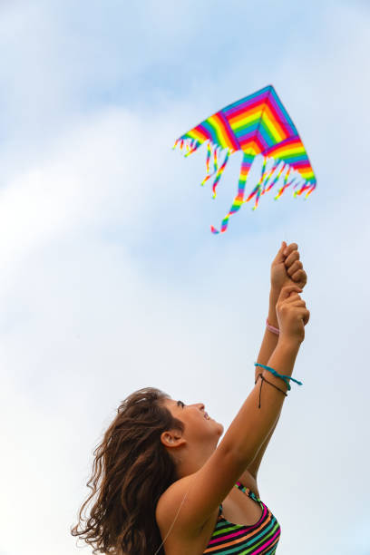 istock Cheerful girl playing with kite on the beach 1511547714