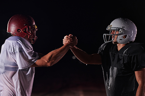 Two american football players face to face in silhouette shadow on white background.