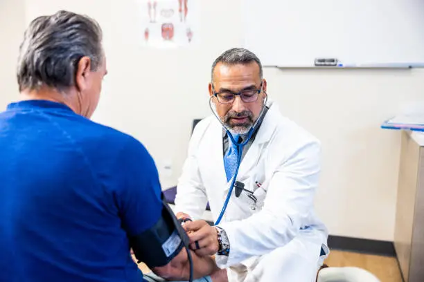 Photo of Doctor taking a senior man's blood pressure reading