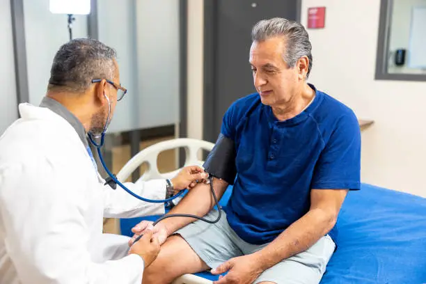 Photo of Doctor taking a senior man's blood pressure reading