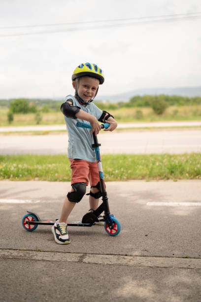 istock Little boy riding scooter. Kids ride kick board 1511604260