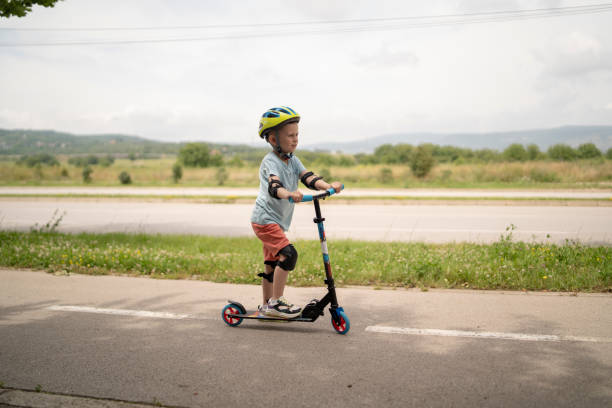 istock Little boy riding scooter. Kids ride kick board 1511604286