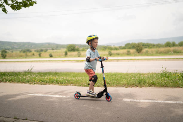 istock Little boy riding scooter. Kids ride kick board 1511604814