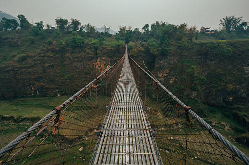The famous Bhalam suspension bridge near Pokhara offers a breathtaking view of the Seti riverbank, attracting tourists to admire the scenic landscape.