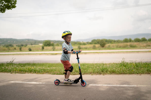 istock Little boy riding scooter. Kids ride kick board 1511606973