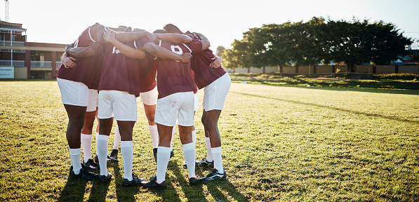 Men, huddle and team on grass field for sports motivation, coordination or collaboration in the outdoors. Group of sport athletes in fitness training, planning or strategy getting ready for game