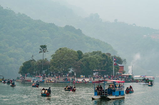 Pokhara,Nepal: Apr 14,2023 - A landscape around Phewa lake in Pokhara city with a many locals relaxing and enjoying lakeside activities.