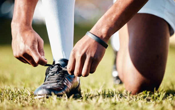 istock Man, hands and shoe tying laces getting ready for sports training, exercise or match and game on grass field. Hand of male in preparation, tie shoes and sport for fitness, start or soccer practice 1511610846