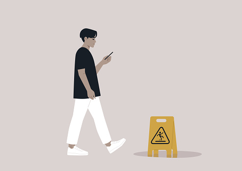 Young Asian character distracted by their smartphone ignoring a yellow wet floor caution sign on their way