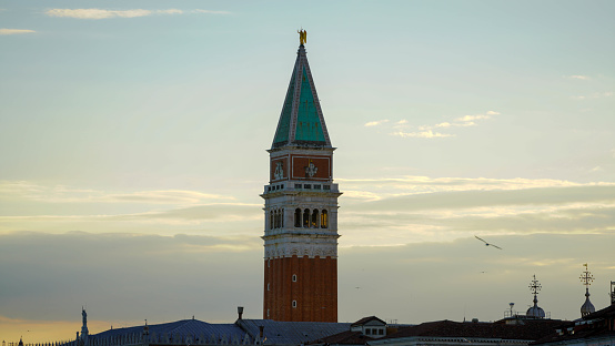 Venice, Italy - April 28 2023: Top of St. Mark's Campanile, the bell tower pertaining to St. Mark's basilica. The bell tower collapsed in 1902 and was reconstructed in 1912.