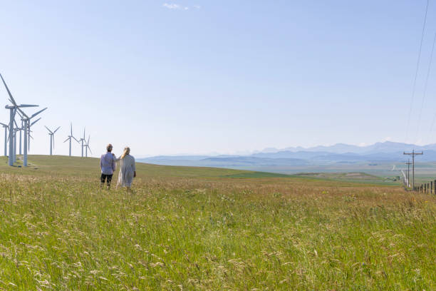 istock Couple relax in meadow below wind turbines 1511698638