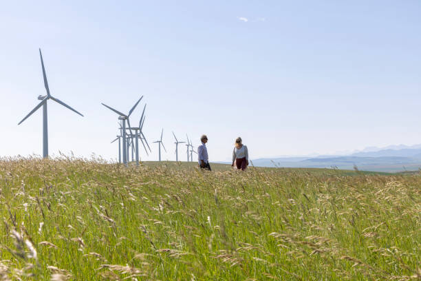 istock Couple relax in meadow below wind turbines 1511700091
