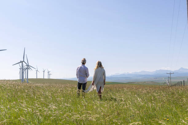 istock Couple relax in meadow below wind turbines 1511700628