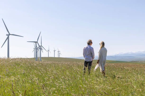 istock Couple relax in meadow below wind turbines 1511702250