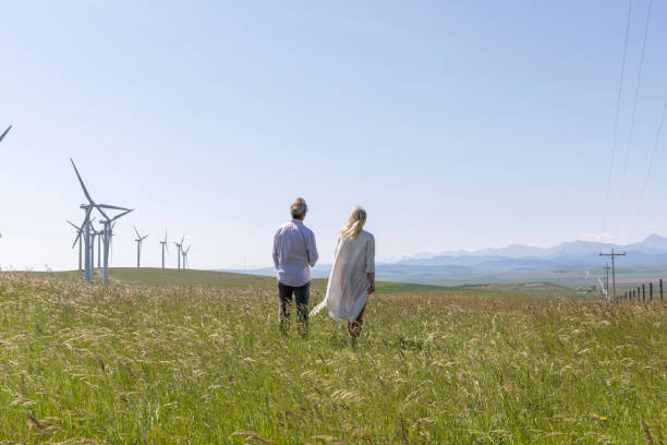 istock Couple relax in meadow below wind turbines 1511702251