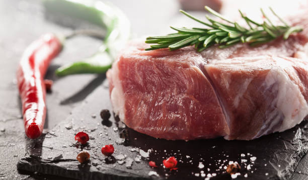 istock Raw fresh meat. Pork steak with rosemary. 1511747499