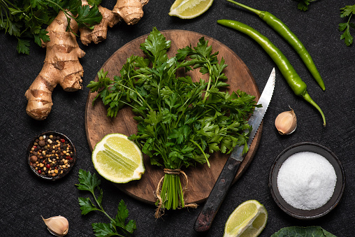 Fresh parsley leaves on a dark wooden cutting board fresh herbs and spices on a wooden table on a dark rustic background Top view