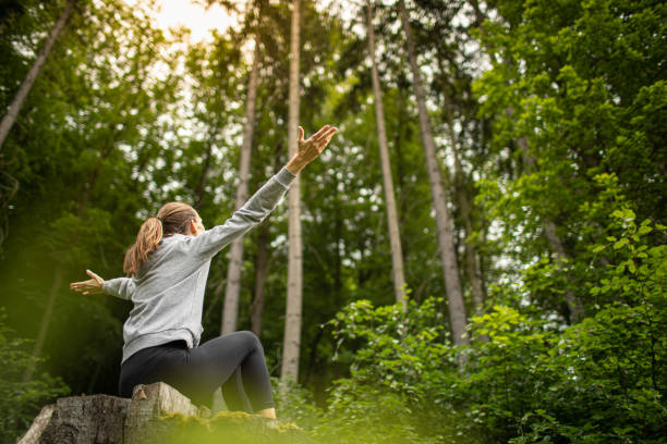 istock Female sitting in a pine forest enjoying feeling free in nature 1511832021