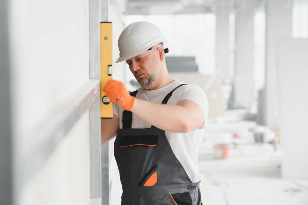 istock Man holding level against plasterboard, interior drywall. Attic renovation 1511845020