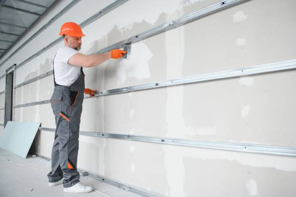 man drywall worker using trowel for plasterer putting stucco on plasterboard white wall. man drywall worker using trowel for plasterer putting stucco on plasterboard white wall hand with a plaster spatula stock pictures, royalty-free photos & images