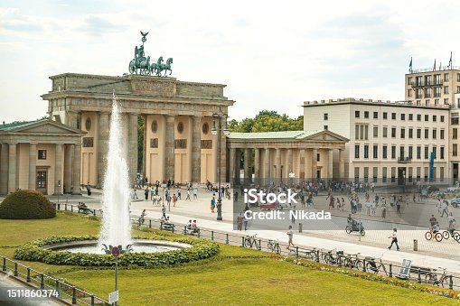 istock fountain and people crowd, Brandenburg Gate, Berlin, daytime, bustling city, blurred motion, lively atmosphere. 1511860374