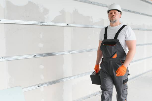 istock Portrait of a builder in working uniform with protective helmet standing with instruments at the construction site indoors 1511870209