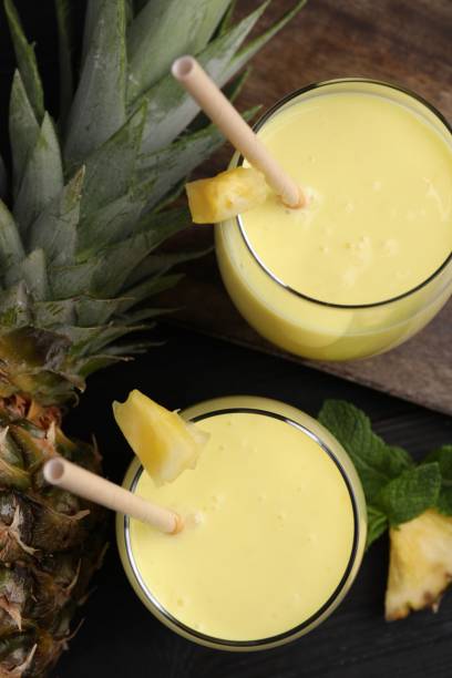 istock Tasty pineapple smoothie, mint and fruit on black table, flat lay 1511918131