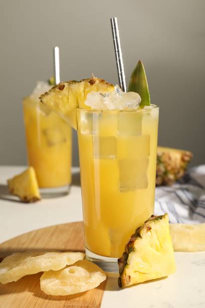istock Tasty pineapple cocktail with ice cubes and delicious fruit on white table 1511918673