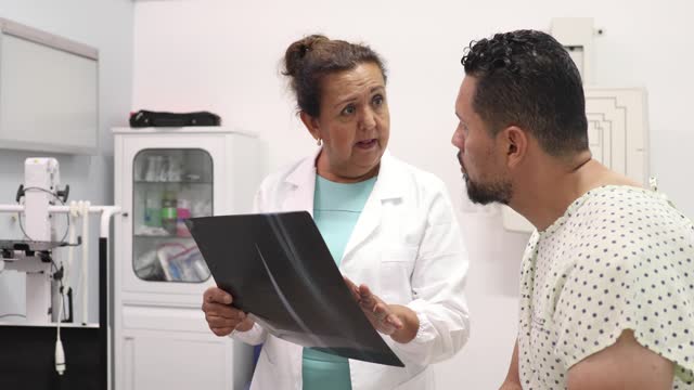 Doctor reviewing x-ray film with patient