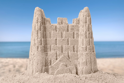 Sand castle on ocean beach, closeup. Outdoor play