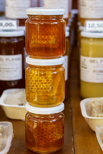 Glass jar of healthful honey on market shelf.