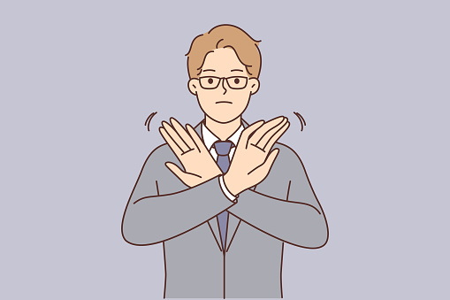 Businessman stops deal by demonstrating forbidding gesture and crossing arms in front of chest as sign of non-cooperation. Businessman in formal suit asks to stop doing actions that harm company.