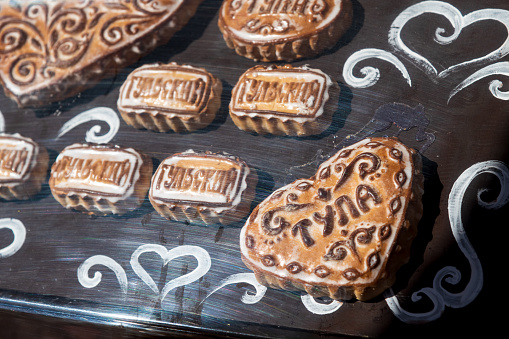 Group of stamped Tula pryaniks (russian traditional gingerbread with honey or jam) lies on souvenir shop showcase. Russian text translation: Tula (name of city) and Tulsky (from Tula). Soft focus.