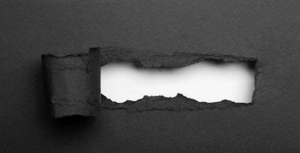 istock Black torn paper with a hole on a red background. Place for an inscription 1511996721