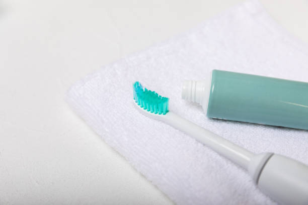 istock Electronic ultrasonic toothbrush and toothpaste on texture background. Items for dental care and caries prevention in the bathroom. Dentistry concept. Copy space. 1512009595