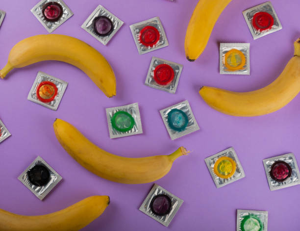 라일락 배경에 화려한 콘돔. 콘돔을 사용하여 임신이나 성병의 가능성을 줄입니다. 안전한 섹스 개념. 복사 공간.플랫 레이 - condom sex education contraceptive aids 뉴스 사진 이미지