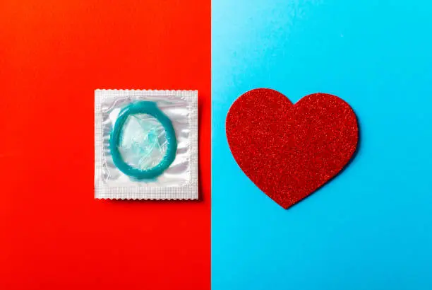 condoms in a red-blue background. The concept of safe sex, prevention of venereal diseases