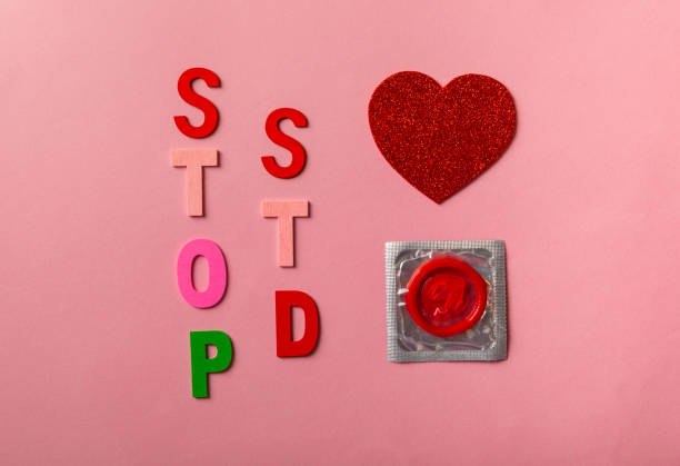 "stop std"라는 문구 배경이 있는 다채로운 블록, 평평하게 놓여 있습니다. 분홍색 배경에 빨간 리본이 있는 구성. 에이즈의 날. - condom sex sexually transmitted disease aids 뉴스 사진 이미지