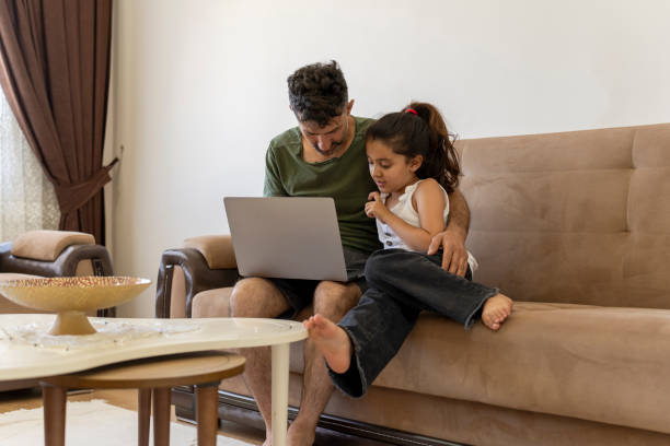 istock Father and daughter working together on laptop at home 1512055877