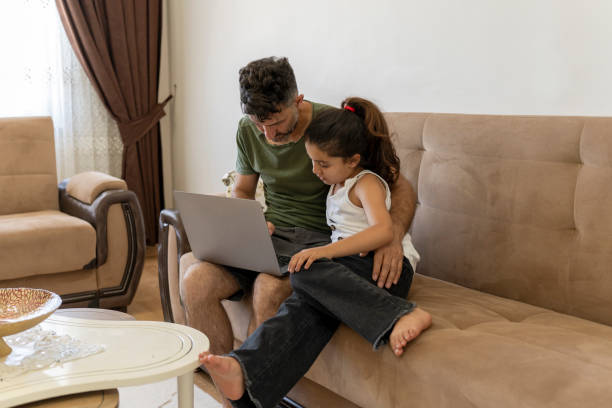 istock Father and daughter working together on laptop at home 1512055887