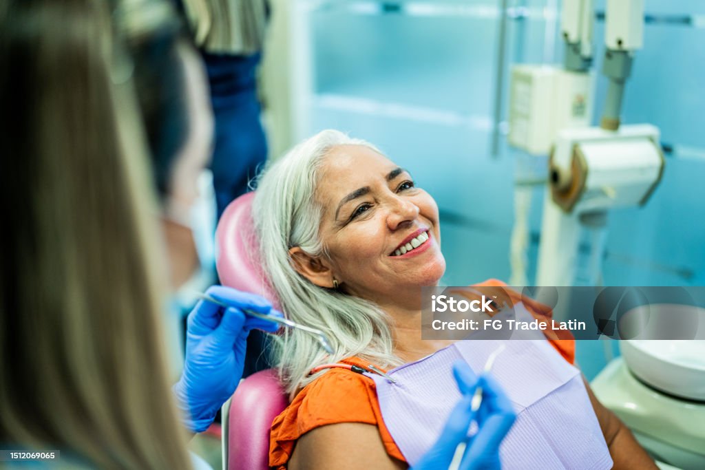 Mature woman having teeth examined by a dentist at her office Dentist Stock Photo