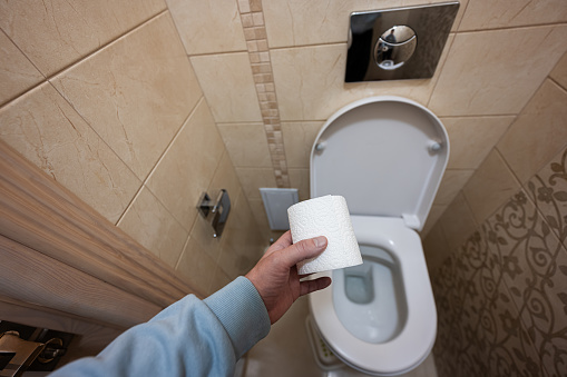 Man hand using toilet paper.