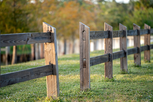 Wooden fence barrier at farm grounds for cattle and territory protection.