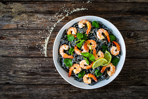 Noodles with prawns and on wooden background